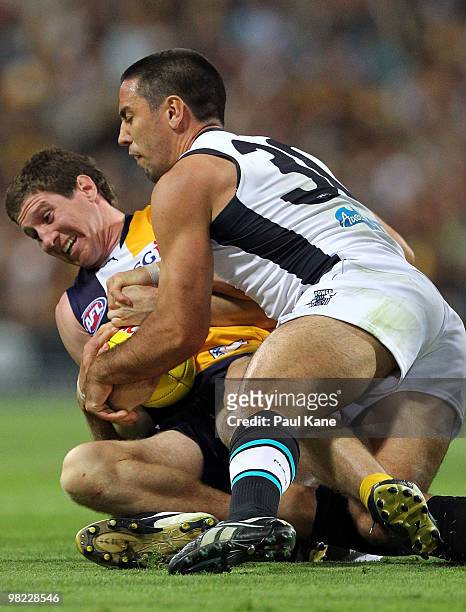 Patrick McGinnity of the Eagles gets tackled by Troy Chaplin of the Power during the round two AFL match between the West Coast Eagles and Port...