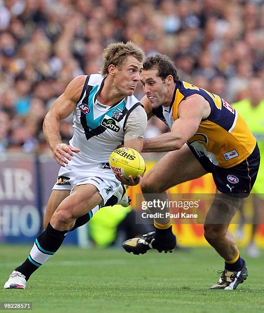 Brett Ebert of the Power evades a tackle by Darren Glass of the Eagles during the round two AFL match between the West Coast Eagles and Port Adelaide...