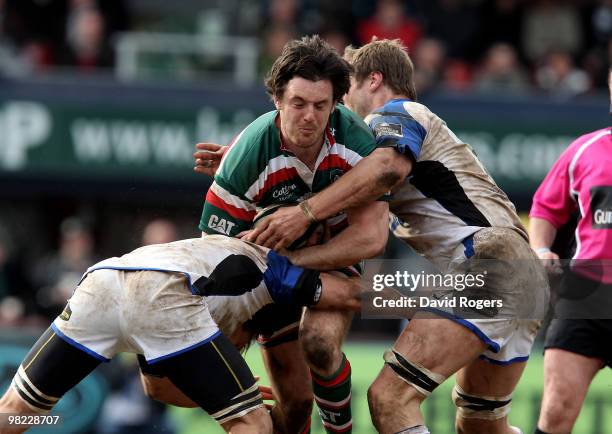 Matt Smith of Leicester is tackled by Andy Beattie and Julian Salvi during the Guinness Premiership match between Leicester Tigers and Bath at...