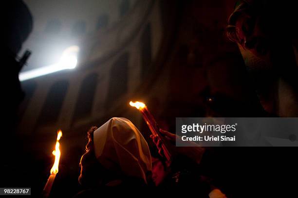 An Orthodox Christian is illuminated by burning candles during the Holy Fire ceremony in the Church of the Holy Sepulchre on April 3, 2010 in...