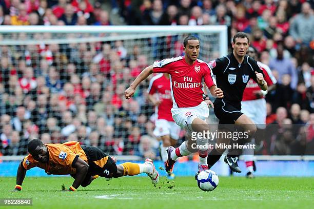 Theo Walcott of Arsenal breaks away from George Elokobi of Wolverhampton Wanderers during the Barclays Premier League match between Arsenal and...
