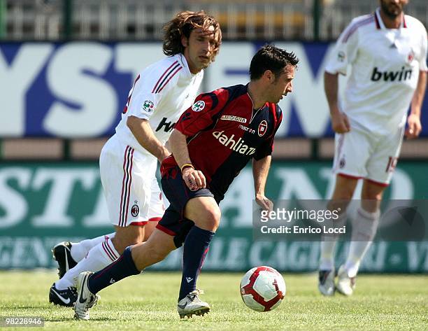 Andrea Cossu of Cagliari takes the ball away from the challenge of Andrea Pirlo of Milan during the Serie A match between Cagliari Calcio and AC...