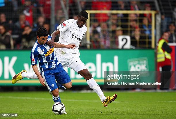 Mohamadou Idrissou of Freiburg fights for the ball with Oguzhan Kefkir of Bochum during the Bundesliga match between SC Freiburg and VfL Bochum at...