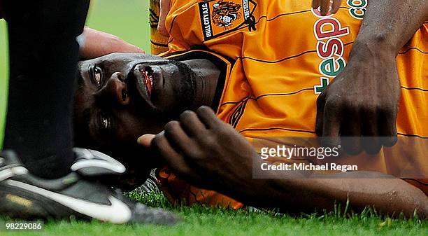 George Boateng of Hull is helped by other players as he lies injured following a kick in the head during the Barclays Premier League match between...