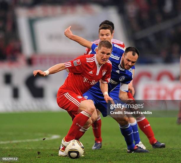 Bastian Schweinstieger of Bayern is challenged by Heiko Westermann of Schalke during the Bundesliga match between FC Schalke 04 and FC Bayern...