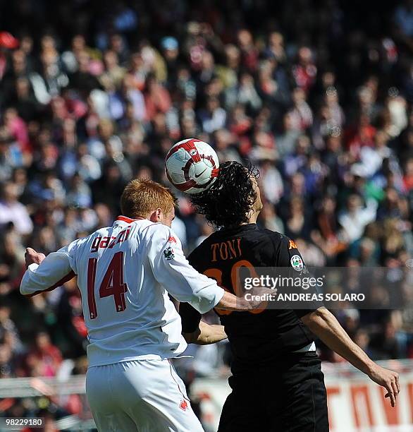 Roma's forward Luca Toni jumps for the ball against Bari's midfielder Alessandro Gazzi during their Italian Serie A football match on April 3, 2010...