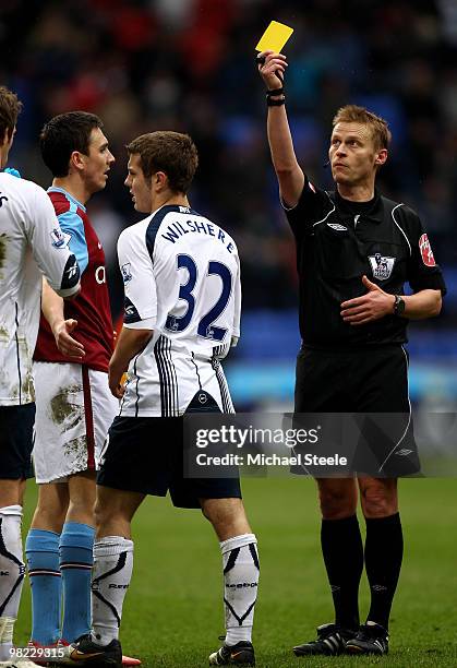 Referee Mark Jones shows the yellow card to Jack Wilshere of Bolton after an end of match scuffle during the Bolton Wanderers and Aston Villa...