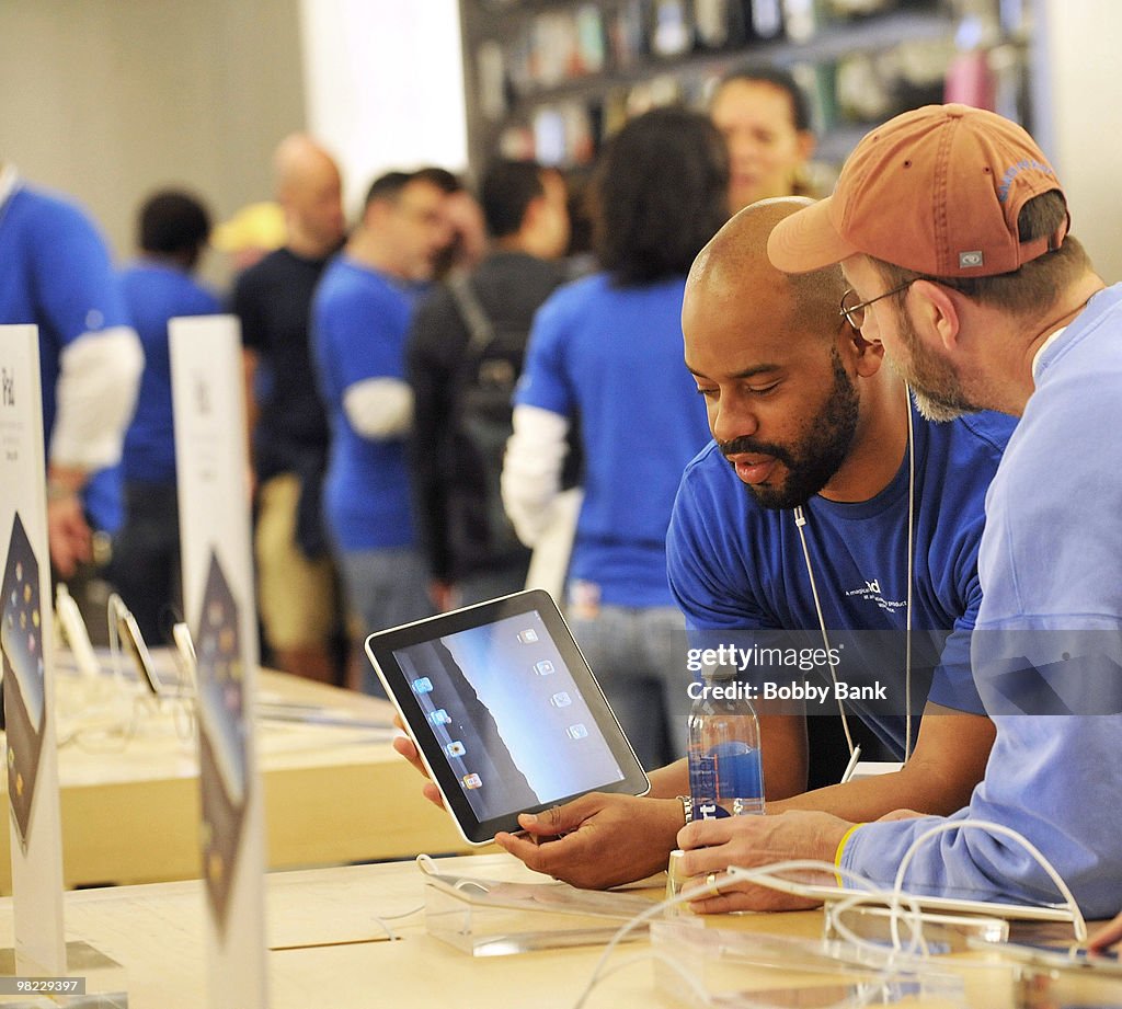 An Apple salesman shows the new iPad to a customer at the Apple Store ...
