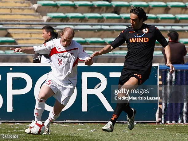 Andrea Masiello of AS Bari is challenged by Luca Toni of AS Roma during the Serie A match between AS Bari and AS Roma at Stadio San Nicola on April...