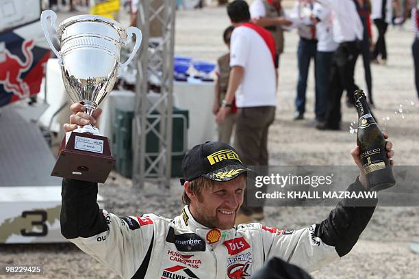 Third-placed winner of the FIA world championship in Jordan Petter Solberg of Norway celebrates at the end of the Jordan Rally in Amman on April 3,...