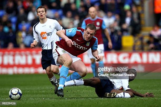 Richard Dunne of Aston Villa is fouled by Fabrice Muamba during the Bolton Wanderers and Aston Villa Barclays Premier League match at The Reebok...
