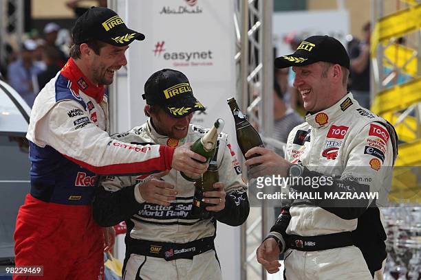 First winner of the FIA world championship in Jordan Frenchman Sebastien Loeb celebrates with third placed Petter Solberg of Norway and his British...