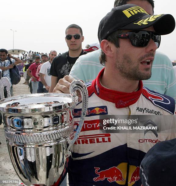 Frenchman Sebastien Loeb holds his trophy at the end of the Jordan Rally in Amman on April 3, 2010. Loeb won the rally, the third leg of the FIA...