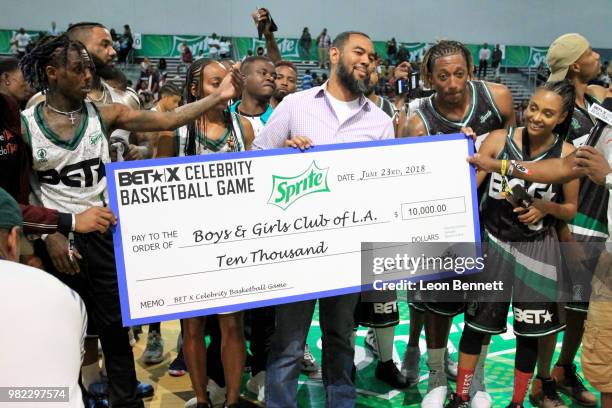 Celebrity players help present a donation to the Boys & Girls Club of America at the Celebrity Basketball Game Sponsored By Sprite during the 2018...