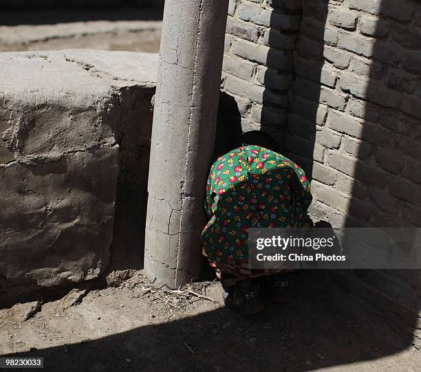 Five-year-old boy avoids strong wind at a black lead mining area on April 3, 2010 in Xinghe County of Ulanqab, Inner Mongolia Autonomous Region,...