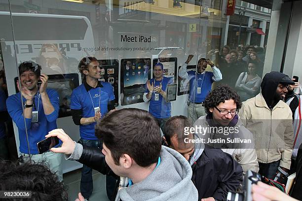 Apple store workers cheer in a display window before opening the store to customers to purchase the new iPad April 3, 2010 in San Francisco,...
