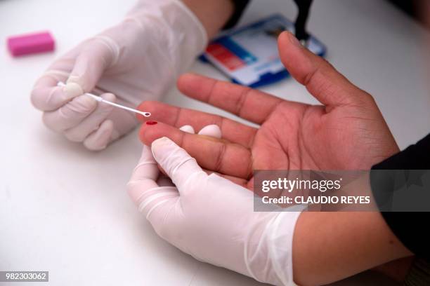 Man undergoes a rapid VIH test during the Gay Pride Parade in Santiago on June 23, 2018. - The initiative aims to encourage prevention, as there is...