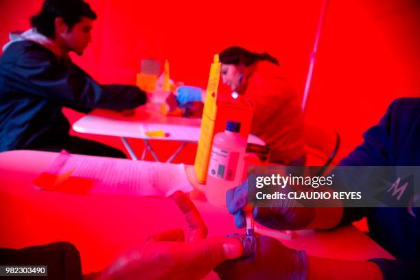 Man undergoes a rapid VIH test during the Gay Pride Parade in Santiago on June 23, 2018. - The initiative aims to encourage prevention, as there is...