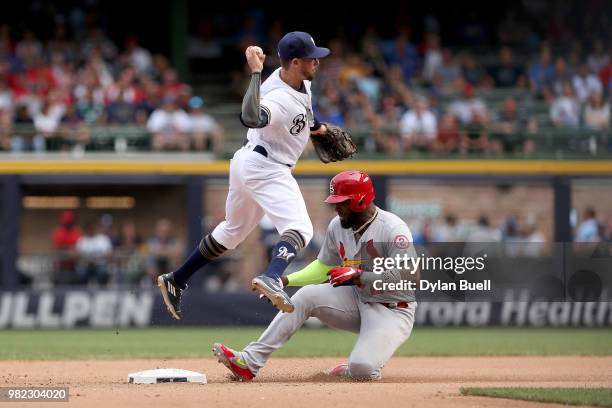 Eric Sogard of the Milwaukee Brewers turns a double play past Marcell Ozuna of the St. Louis Cardinals in the eighth inning at Miller Park on June...