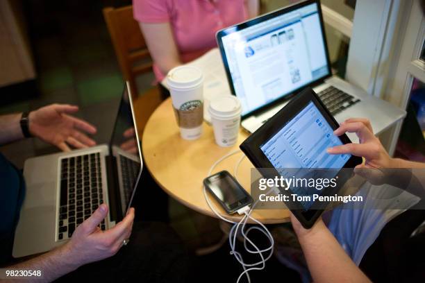 An new iPad owner syncs the device with his laptop computer while visiting a Starbucks Coffee location April 3, 2010 in Fort Worth, Texas. Debuting...