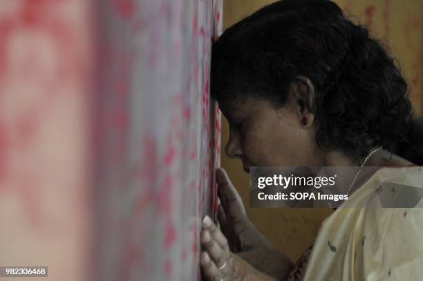 An Indian woman seen praying before the holy sign of Swastika during the Ambubachi festival. The swastika is a geometrical figure and an ancient...