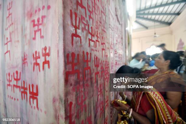 Indian women seen drawing the holy sign of Swastika during the Ambubachi festival. The swastika is a geometrical figure and an ancient religious icon...