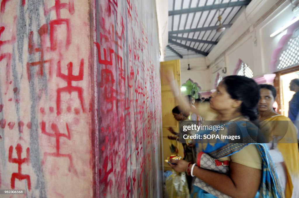 An Indian woman seen drawing the holy sign of Swastika...