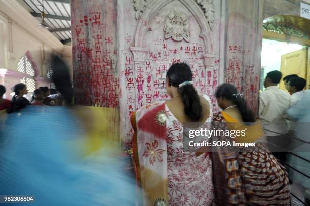 Indian women seen drawing the holy sign of Swastika during the Ambubachi festival. The swastika is a geometrical figure and an ancient religious icon...