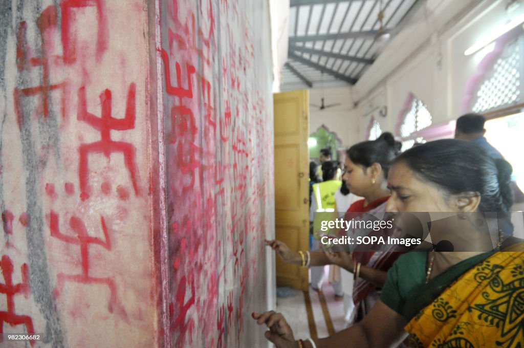 Indian women seen drawing the holy sign of Swastika during...