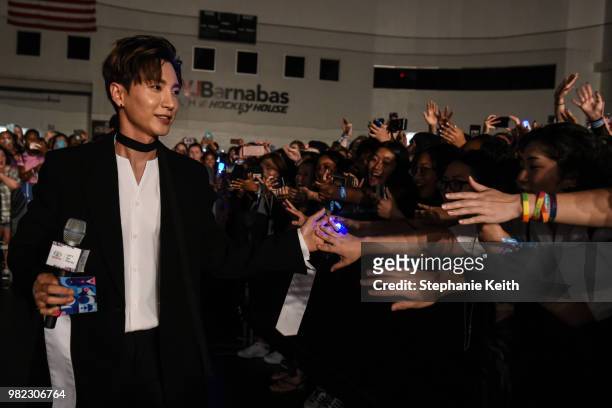 Singer in Super Junior, a Korean pop music band, shakes hands with fans at a convention, called Kcon, that brings together some of the most popular...