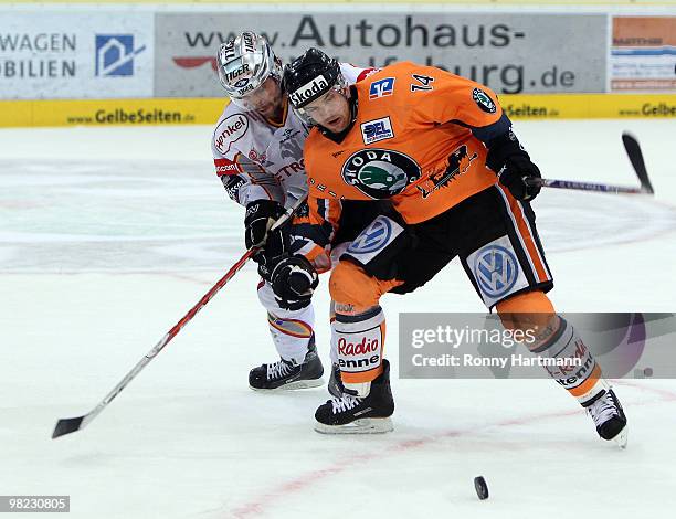 Norm Milley of Wolfsburg challenges for the puck with Marian Bazany of DEG Metro Stars during the third DEL quarter final play-off game between...