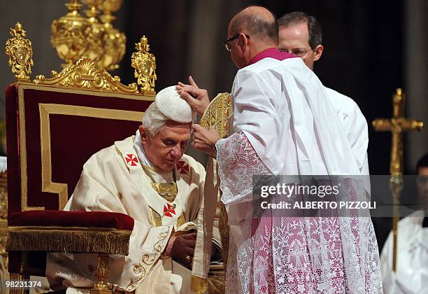 Prelate adjust the Pope Benedict XVI skullcap during the Easter vigil mass in St. Peter's Basilica at the Vatican, on April 3, 2010. The Pontiff...