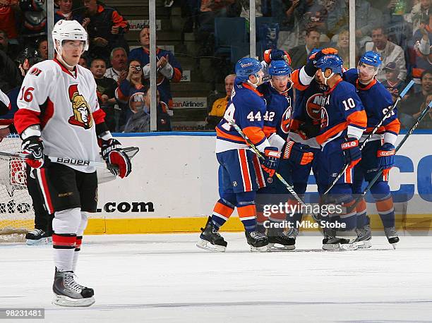 Bobby Butler of the Ottawa Senators looks on as Dylan Reese of the New York Islanders is congratulated by teammates Freddy Meyer, Richard Park, and...