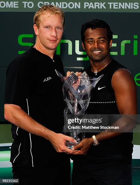 Lukas Dlouhy of the Czech Republic and Leander Paes of India hold the trophy after defeating Mahesh Bhupathi of India and Max Mirnyi of Belarus to...