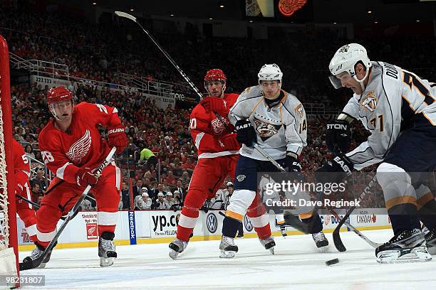 Dumont of the Nashville Predators looks to take a shot as teammate Dustin Boyd ties up Drew Miller of the Detroit Red Wings and Brian Rafalksi...