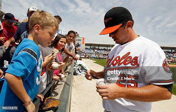 Infielder Garrett Atkins of the Baltimore Orioles signs autographs prior to the start of the Grapefruit League Spring Training Game against the New...