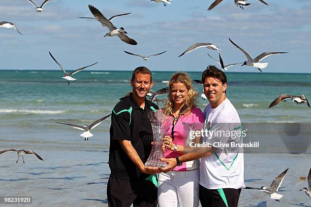 Coach Wim Fissette, Kim Clijsters of Belgium and trainer Sam Verslegers pose on the beach with the trophy after Clijsters defeated Venus Williams of...