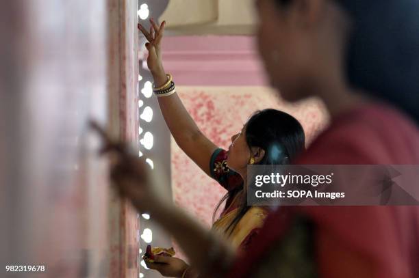 An Indian woman seen drawing the holy sign of Swastika during the Ambubachi festival. The swastika is a geometrical figure and an ancient religious...