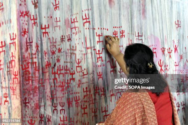 An Indian woman seen drawing the holy sign of Swastika during the Ambubachi festival. The swastika is a geometrical figure and an ancient religious...