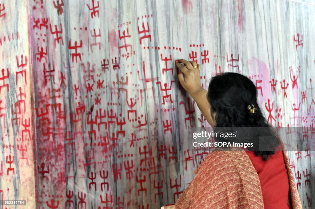 An Indian woman seen drawing the holy sign of Swastika...
