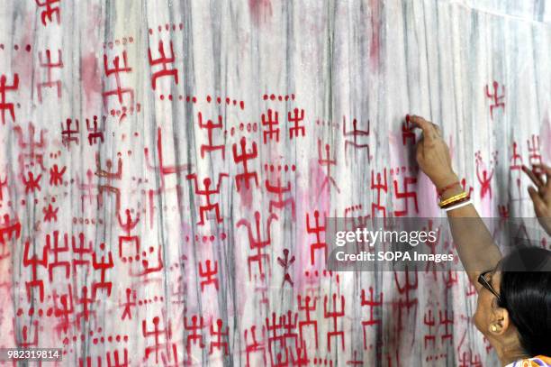 Indian women seen drawing the holy sign of Swastika during the Ambubachi festival. The swastika is a geometrical figure and an ancient religious icon...