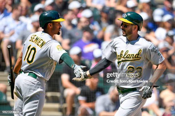 Oakland Athletics left fielder Matt Joyce shakes hands with Oakland Athletics shortstop Marcus Semien after scoring against the Chicago White Sox on...