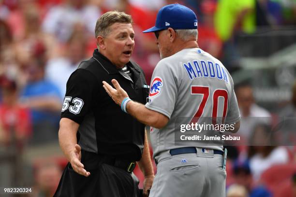 Home plate umpire Greg Gibson has a discussion with Manager Joe Maddon of the Chicago Cubs in the fourth inning during a game against the Cincinnati...