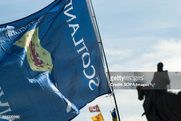 Flag that reads "SCOTLAND" and features the Rampant Lion pictured with Robert the Bruce's statue in the background. Thousands of Scottish...