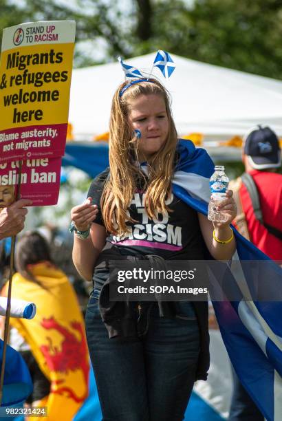 Teenager is seen wearing a a headband with the Scottish flag and a shirt that reads "STAND UP TO RACISM" Thousands of Scottish independence...