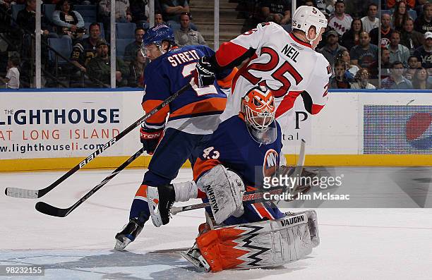 Martin Biron of the New York Islanders makes a save as teammate Mark Streit defends against Chris Neil of the Ottawa Senators on April 3, 2010 at...