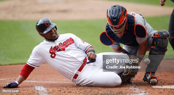 Edwin Encarnacion of the Cleveland Indians slides at home plate to score a run as James McCann of the Detroit Tigers drops the ball in the first...