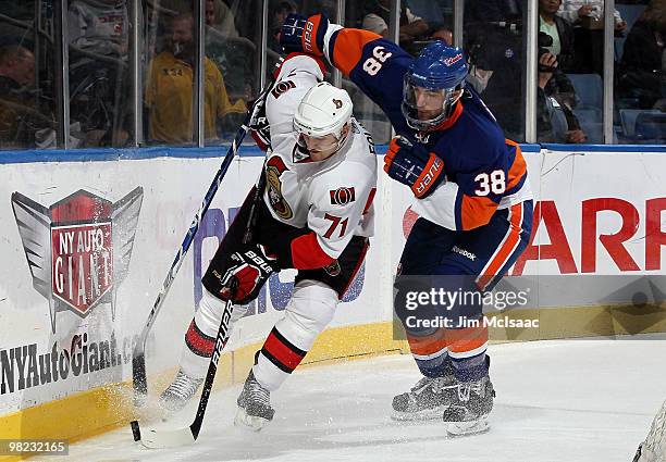 Jack Hillen of the New York Islanders defends against Nick Foligno of the Ottawa Senators on April 3, 2010 at Nassau Coliseum in Uniondale, New York....