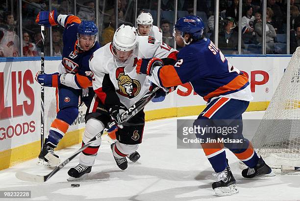 Mark Streit and Andrew MacDonald of the New York Islanders defend against Mike Fisher of the Ottawa Senators on April 3, 2010 at Nassau Coliseum in...
