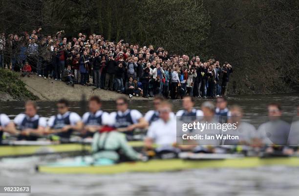 Spectators watch from the river bank during the 156th Oxford and Cambridge University Boat Race on the River Thames on April 3, 2010 in London,...